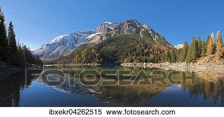 Bergsee, Obernbergersee mit Spiegelung im Herbst, hinten Berg Tribulaun mit Schnee, Obernbergtal, Stubaier Alpen, Tirol, Osterreich, Europa View Large Photo Image Stock Photography - Bergsee, Obernbergersee mit Spiegelung im Herbst, hinten Berg Tribulaun mit Schnee, Obernbergtal, Stubaier Alpen, Tirol, Osterreich, Europa. Fotosearch