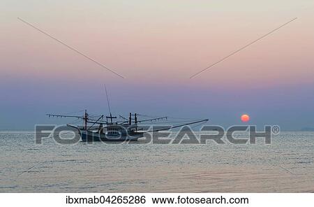 Stock Photograph - Boot im Meer bei Sonnenuntergang vor kleinen Inseln, Insel Koh Samui, Golf von Thailand, Thailand, Asien. Fotosearch