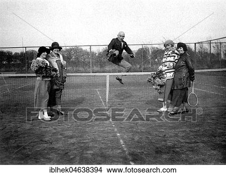 Picture - Bragger on the tennis court, man jumps over the tennis net to impress four women, ca. 1928, 1920s, exact place unknown, Germany, Europe. Fotosearch