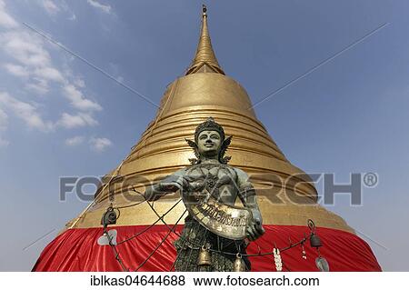 Bronze figure in front of the Golden Chedi on Phu Khao Thong, Golden Mountain in Wat Saket, Pom Prap Sattru Phai District, Bangkok, Thailand, Asia View Large Photo Image Stock Photo - Bronze figure in front of the Golden Chedi on Phu Khao Thong, Golden Mountain in Wat Saket, Pom Prap Sattru Phai District, Bangkok, Thailand, Asia. Fotosearch