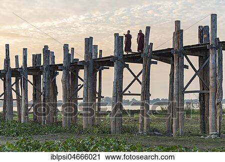 Buddhist monks walking on the U Bein Bridge over Taungthaman Lake, Amarapura, Myanmar, Asia View Large Photo Image Stock Image - Buddhist monks walking on the U Bein Bridge over Taungthaman Lake, Amarapura, Myanmar, Asia. Fotosearch