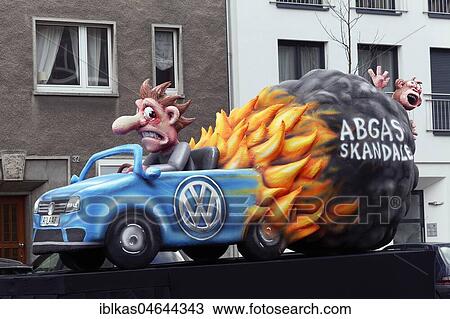 Stock Image - Burning VW car with monkey in exhaust gas cloud, exhaust gas scandal, animal testing with exhaust fumes, motto caravan during Carnival Monday procession 2018, Düsseldorf, North Rhine-Westphalia, Germany, Europe. Fotosearch