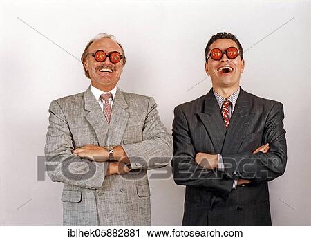 Stock Image - Businessmen with tomatoes on their eyes, laugh, funny, blind, Berlin, Germany, Europe. Fotosearch