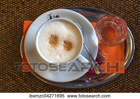 Cappuccino mit einem Glas Wasser auf einem Tablett View Large Photo Image Stock Photography - Cappuccino mit einem Glas Wasser auf einem Tablett. Fotosearch