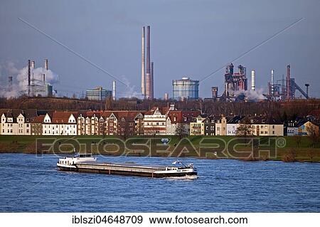 Cargo ship on the Rhine, residential buildings with Thyssenkrupp plant, Duisburg, Ruhr Area, North Rhine-Westphalia, Germany, Europe View Large Photo Image Stock Photo - Cargo ship on the Rhine, residential buildings with Thyssenkrupp plant, Duisburg, Ruhr Area, North Rhine-Westphalia, Germany, Europe. Fotosearch