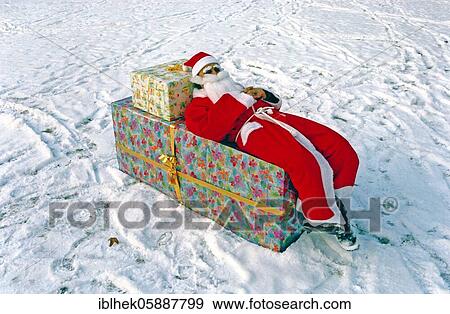 Christmas, Presents, Santa Claus lies on a present, lazy, Berlin, Germany, Europe View Large Photo Image Stock Photo - Christmas, Presents, Santa Claus lies on a present, lazy, Berlin, Germany, Europe. Fotosearch