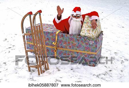 Stock Photo - Christmas, Santa Claus sitting in the present, Berlin, Germany, Europe. Fotosearch