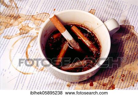 Stock Photo - Cigarettes in a coffee cup, disgusting, ashtray, Berlin, Germany, Europe. Fotosearch