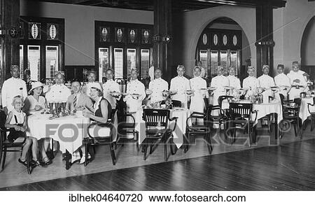 Stock Image - Colonial history, waiters take care of a family of four in the restaurant, 1920s, exact place unknown, Indonesia, Asia. Fotosearch