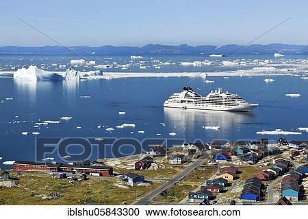 Stock Image - Colourful houses with views into Disko Bay to the cruise ship Seabourn Quest, Ilulissat, West Greenland, Greenland, North America. Fotosearch