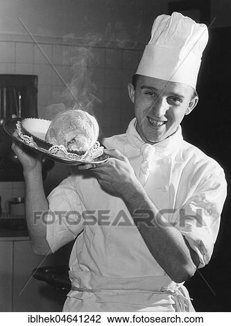 Stock Image - Cook serving knuckle of pork, 1960s, Berlin, Germany, Europe. Fotosearch