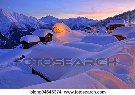 Picture - Deeply snow-covered chapel Maria zum Schnee in the village centre, in the back Fletschhorn 3985m cathedral 4545m and Matterhorn 4478m at dusk, Bettmeralp, Aletsch area, Upper Valais, Valais, Switzerland, Europe. Fotosearch