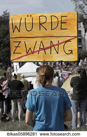 Stock Image - Demo against corona rules on the Rhine meadows, young woman with poster dignity instead of coercion, Düsseldorf, North Rhine-Westphalia, Germany, Europe. Fotosearch