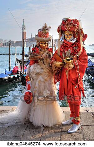 Picture - Disguised couple with Venetian masks at the lagoon, behind island San Giorgio, carnival in Venice, Italy, Europe. Fotosearch