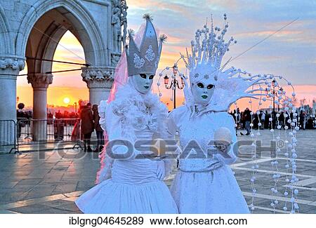 Stock Photo - Disguised couple with Venetian masks at sunset, carnival in Venice, Italy, Europe. Fotosearch