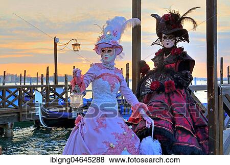Stock Photo - Disguised couple with Venetian masks on the lagoon, carnival in Venice, Italy, Europe. Fotosearch