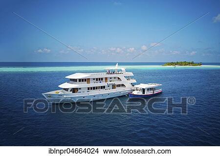 Picture - Diving safari ship MS Keana with diving dhoni anchored off an uninhabited palm island, Ari Atoll, Indian Ocean, Maldives, Asia. Fotosearch