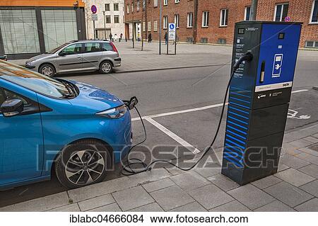 Electric car is charged at green electricity charging station with charging cable, Munich, Bavaria, Germany, Europe View Large Photo Image Picture - Electric car is charged at green electricity charging station with charging cable, Munich, Bavaria, Germany, Europe. Fotosearch
