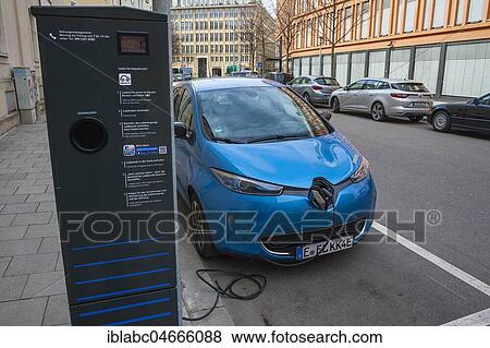 Stock Photo - Electric car is charged at green electricity charging station with charging cable, Munich, Bavaria, Germany, Europe. Fotosearch