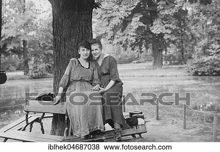 Excursion into the countryside, two friends sitting under a tree posing for the camera, 1910s, Germany, Europe View Large Photo Image Stock Photo - Excursion into the countryside, two friends sitting under a tree posing for the camera, 1910s, Germany, Europe. Fotosearch