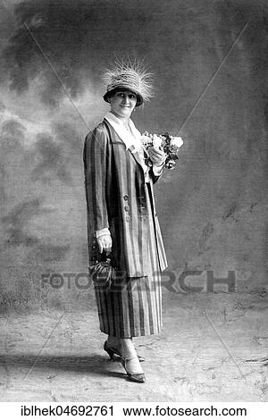 Stock Image - Fashion, hat fashion, woman in striped costume, handbag and feather hat, 1920s, Germany, Europe. Fotosearch