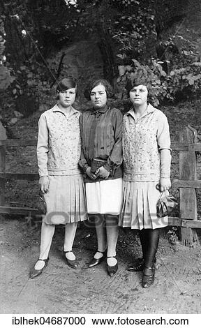 Stock Image - Fashion, three young women with handbags, pleated skirts and blouses, 1920s, Germany, Europe. Fotosearch