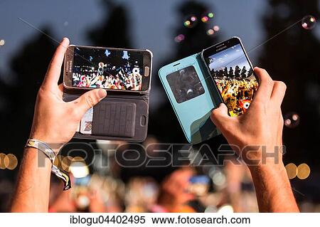 Festival visitor takes photos with Iphone from the British band Skunk Anansie and singer Deborah Anne Dyer alias Skin live at the 26th Heitere Open Air in Zofingen, Aargau, Switzerland, Europe View Large Photo Image Stock Photography - Festival visitor takes photos with Iphone from the British band Skunk Anansie and singer Deborah Anne Dyer alias Skin live at the 26th Heitere Open Air in Zofingen, Aargau, Switzerland, Europe. Fotosearch