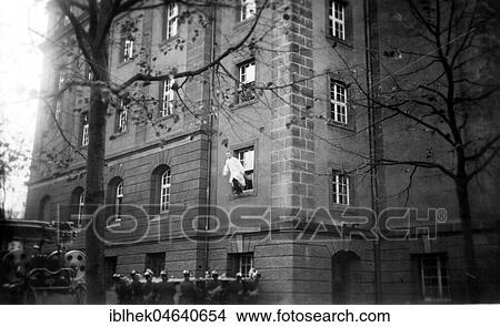 Picture - Fire brigade during an exercise with a jumping blanket, man jumps out of a window, rescue, 1920s, exact place unknown, Germany, Europe. Fotosearch