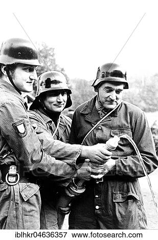 Stock Photo - Firefighters with hose, ca. 1970s, exact place unknown, Germany, Europe. Fotosearch
