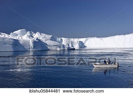 Stock Image - Fishermen with boat in front of gigantic icebergs, UNESCO World Natural Heritage, Ilulissat, Disko Bay, West Greenland, Greenland, North America. Fotosearch