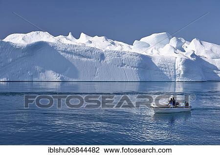 Stock Image - Fishermen with boat in front of gigantic icebergs, UNESCO World Natural Heritage, Ilulissat, Disko Bay, West Greenland, Greenland, North America. Fotosearch