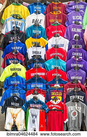Picture - Football jerseys with names of football players for sale at sales stall, Florence, Italy, Europe. Fotosearch