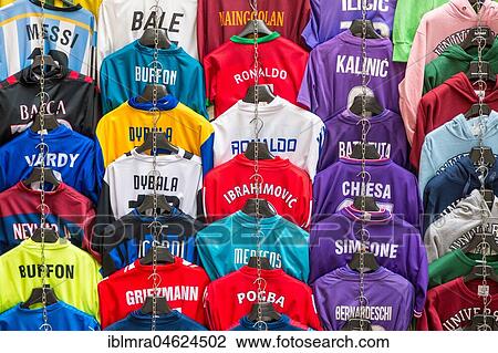 Stock Image - Football jerseys with names of football players for sale at sales stall, Florence, Italy, Europe. Fotosearch
