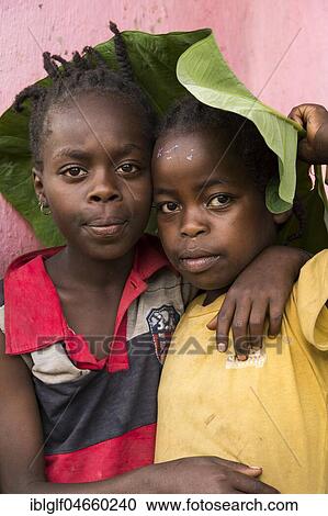 Stock Image - Girl and boy ca 6-7 years with banana leaf on the head, portrait, Ari tribe, Southern Nations Nationalities and Peoples' Region, Ethiopia, Africa. Fotosearch