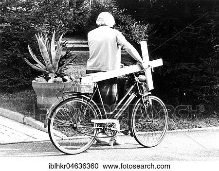 Stock Image - Grandma with cross on bicycle, ca. 1970s, exact place unknown, Germany, Europe. Fotosearch
