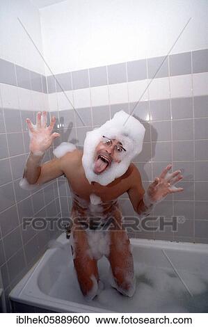 Stock Image - Grimaces, man makes faces in bathtub, bath foam, Berlin, Germany, Europe. Fotosearch