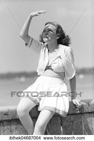 Picture - Holiday, swimwear, woman in beachwear protects herself from the sun, 1940s, Wannsee, Berlin, Germany, Europe. Fotosearch