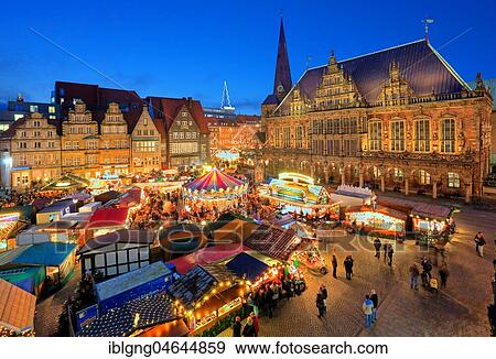Stock Photo - Illuminated Christmas market on the town hall square, in front of town houses, tower of the Liebfrauenkirche and town hall, evening twilight, Bremen, Germany, Europe. Fotosearch