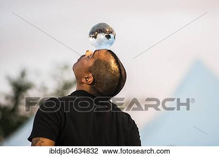 Stock Image - Juggler with crystal ball, Kulturufer, Festival with street artists, Friedrichshafen, Lake Constance, Baden-Württemberg, Germany, Europe. Fotosearch