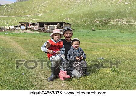 Stock Photograph - Kyrgyz man with his two children, Sary Jaz valley, Issyk Kul region, Kyrgyzstan, Asia. Fotosearch