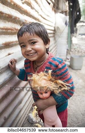 Laughing little child with doll in the slum at the Ghazipur garbage dump, New Delhi, India, Asia View Large Photo Image Stock Photo - Laughing little child with doll in the slum at the Ghazipur garbage dump, New Delhi, India, Asia. Fotosearch
