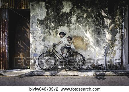 Stock Image - Little Children on a Bicycle, mural, Streetart, by Lithuanian artist Ernest Zacharevic, George Town Festival 2012, Armenian Street, George Town, Penang, Malaysia, Asia. Fotosearch