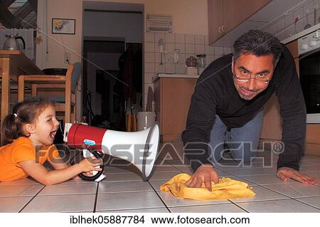 Picture - Little girl commands her daddy with the megaphone, cleaning, Lauda, Germany, Europe. Fotosearch