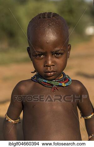 Little girl, serious look, with fly on eye, portrait, Hamer tribe, Turmi market, Southern Nations Nationalities and Peoples' Region, Ethiopia, Africa View Large Photo Image Picture - Little girl, serious look, with fly on eye, portrait, Hamer tribe, Turmi market, Southern Nations Nationalities and Peoples' Region, Ethiopia, Africa. Fotosearch