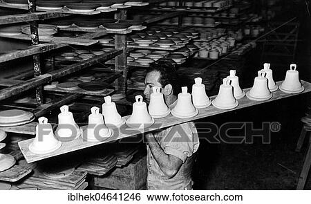 Stock Photograph - Man transports ceramic bells for firing, 1960s, Berlin, Germany, Europe. Fotosearch