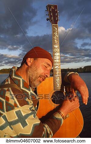 Man with guitar on a jetty at the lake, Mecklenburg Lake District, Mecklenburg-Western Pomerania, Germany, Europe View Large Photo Image Stock Image - Man with guitar on a jetty at the lake, Mecklenburg Lake District, Mecklenburg-Western Pomerania, Germany, Europe. Fotosearch