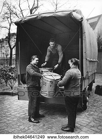Stock Photo - Men lift canisters from trucks, 1960s, Berlin, Germany, Europe. Fotosearch