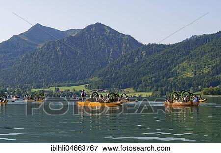 Stock Photo - Men wearing traditional costumes in festively decorated squares, wooden boats, on the Schliersee lake, behind Brecherspitze, Alt-Schlierseer-Kirchtag, Schliersee, Upper Bavaria, Bavaria, Germany, Europe. Fotosearch