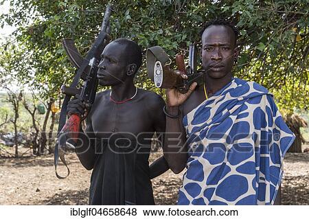 Stock Photo - Men with Kalashnikovs, AK47, warriors, Mursi tribe, Southern Nations Nationalities and Peoples' Region, Ethiopia, Africa. Fotosearch