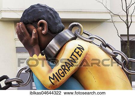Stock Image - Migrant from Africa, double chained, slavery sponsored by the EU, political caricature, motto caravan during Carnival Monday procession 2018, Düsseldorf, North Rhine-Westphalia, Germany, Europe. Fotosearch